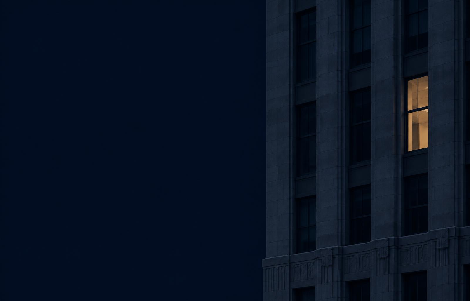 A single illuminated office window at night